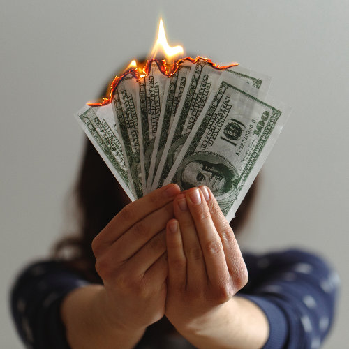 Hands holding burning 100 dollar bills - Photo by Jp Valery on Unsplash